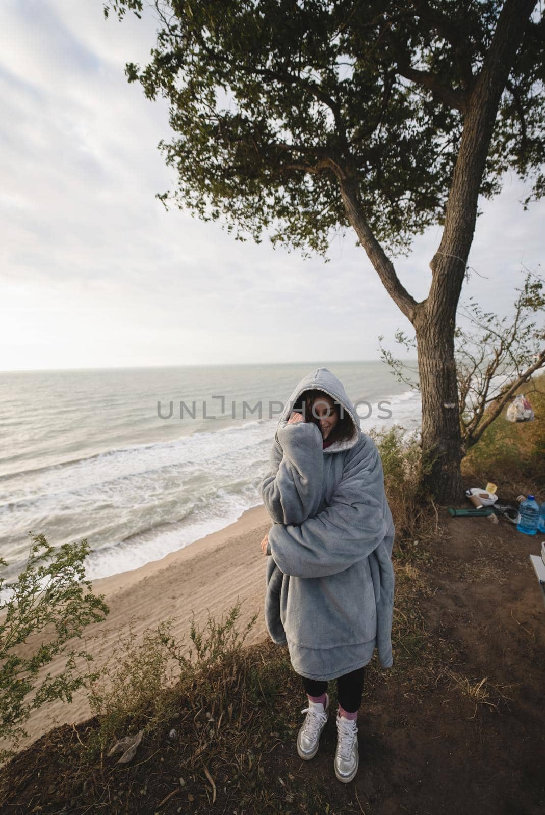 Woman on cold autumn seashore posing at camera