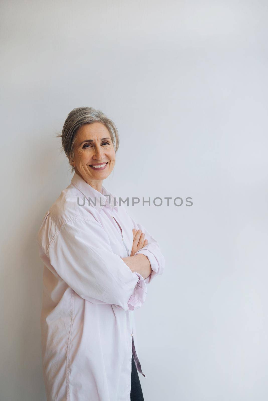 Smiling confident middle aged business woman standing isolated on white background.