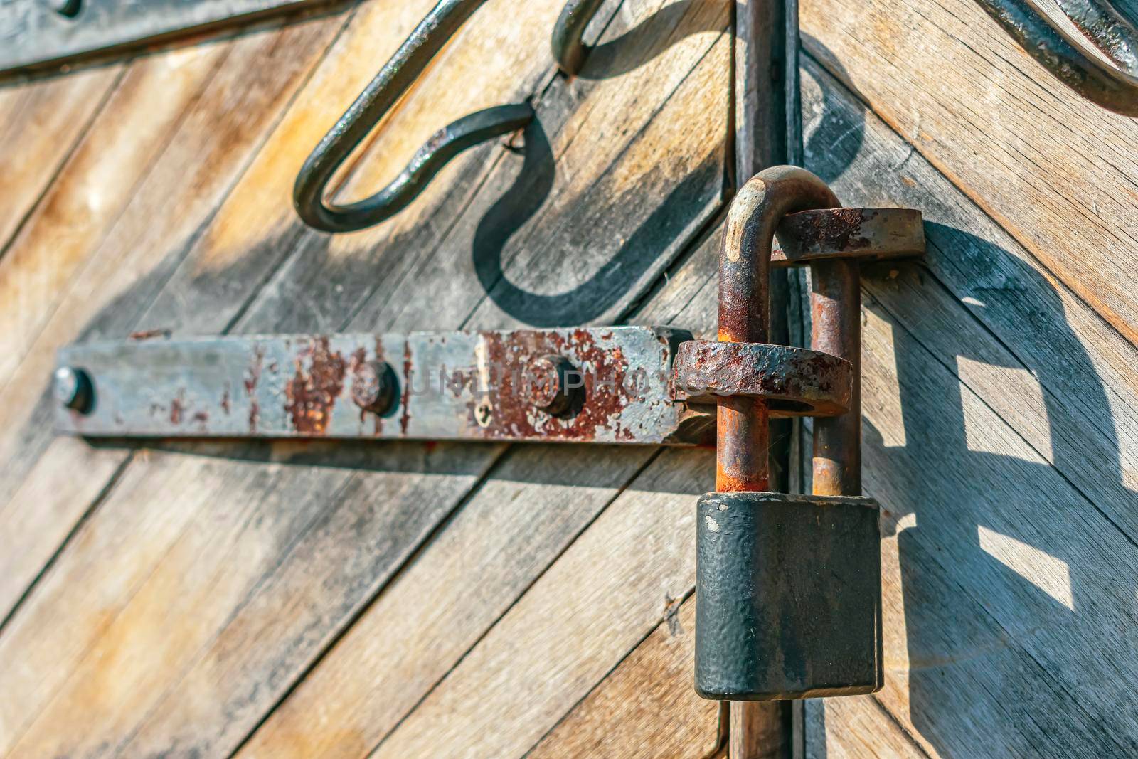 Rusty padlock locks the old wooden gates of the 18th century barracks