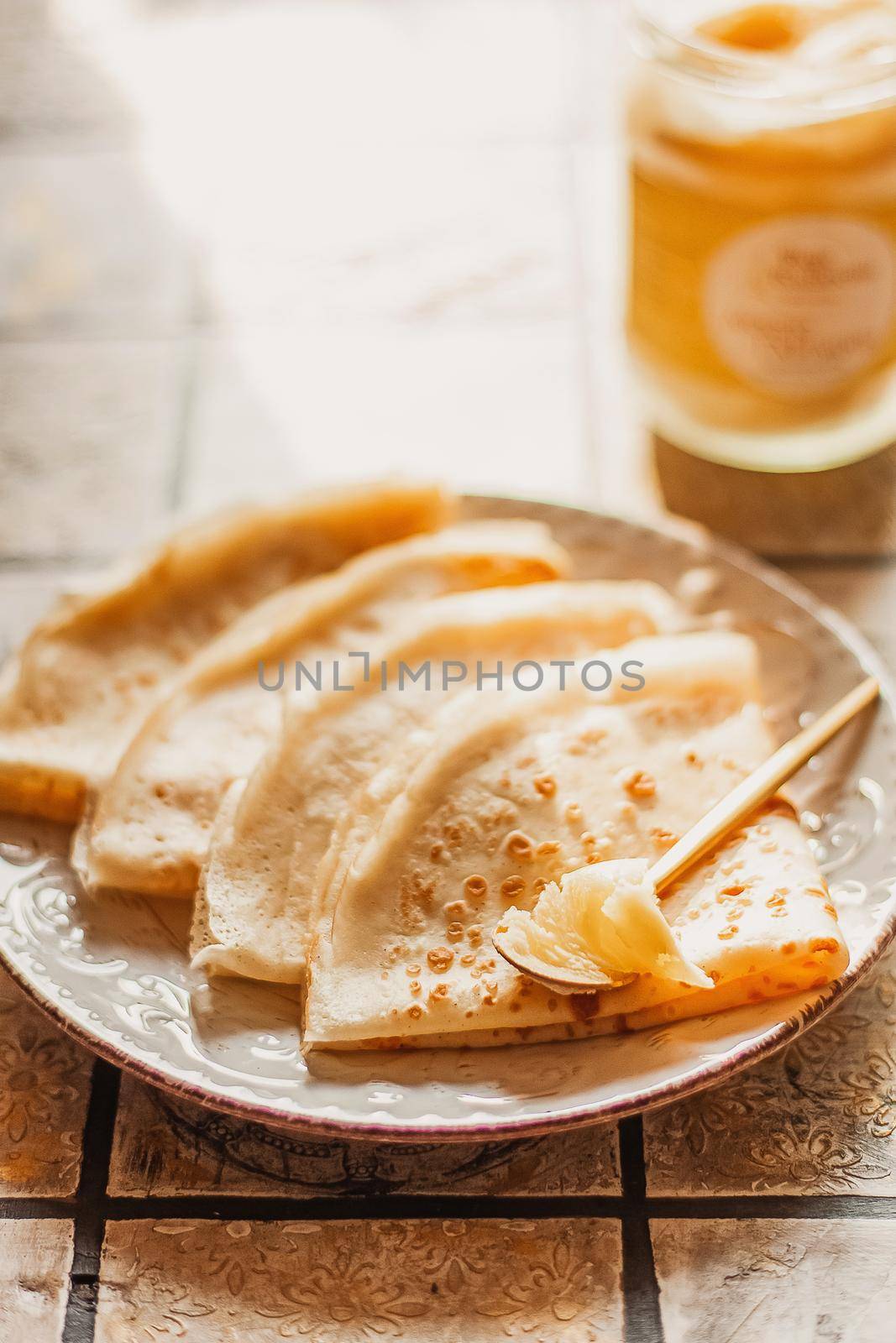 Ghee butter in glass jar and pancakes on table. Healthy eating, breakfast.