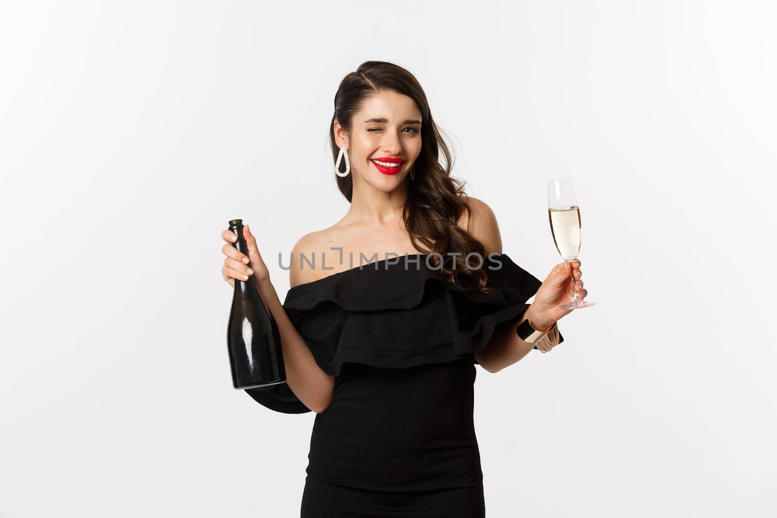 Celebration and party concept. Stylish brunette woman in glamour dress holding bottle and glass of champagne, having fun on new year holiday by Benzoix