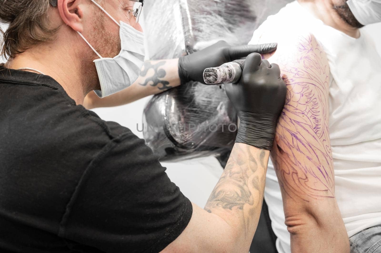 Tattoo artist making tattoo at the studio. High quality photography