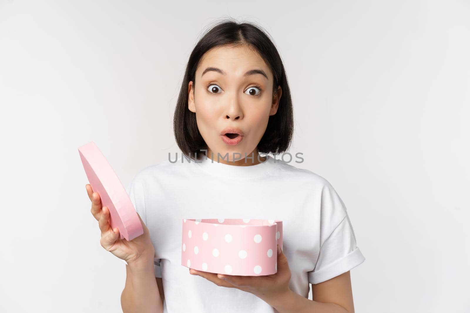 Happy asian woman, girlfriend open box with valentines day gift, receive romantic present, standing over white background. copy space