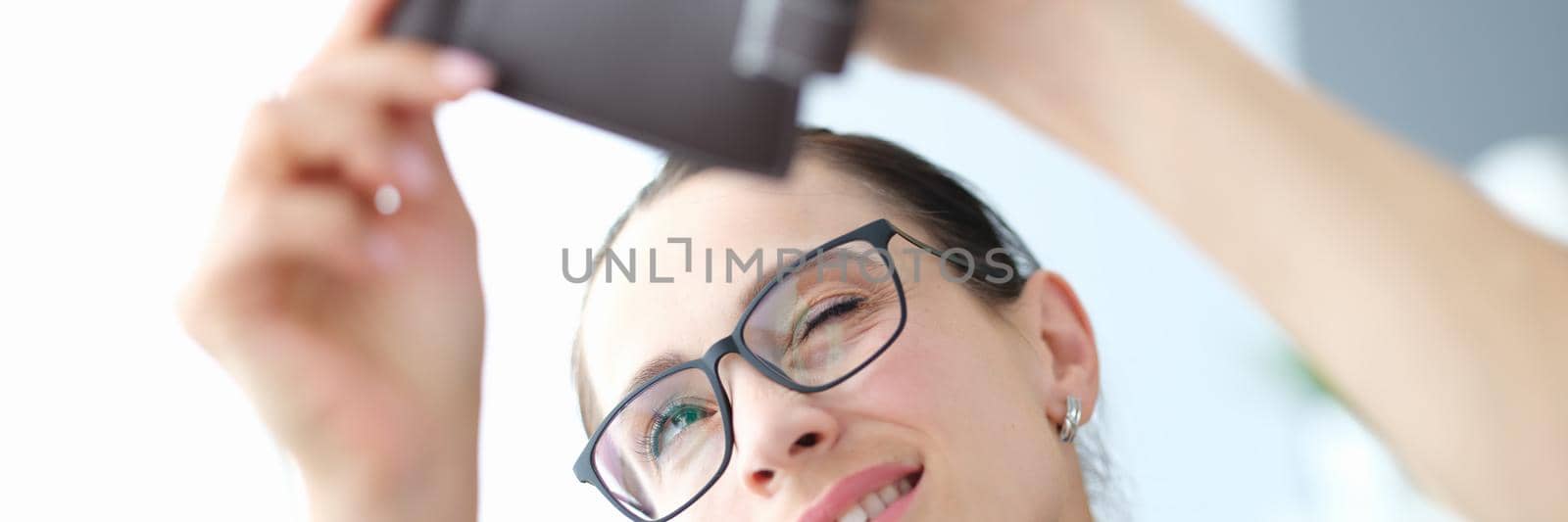 Portrait of young woman with glasses looks into empty purse. Constant shortage of money concept