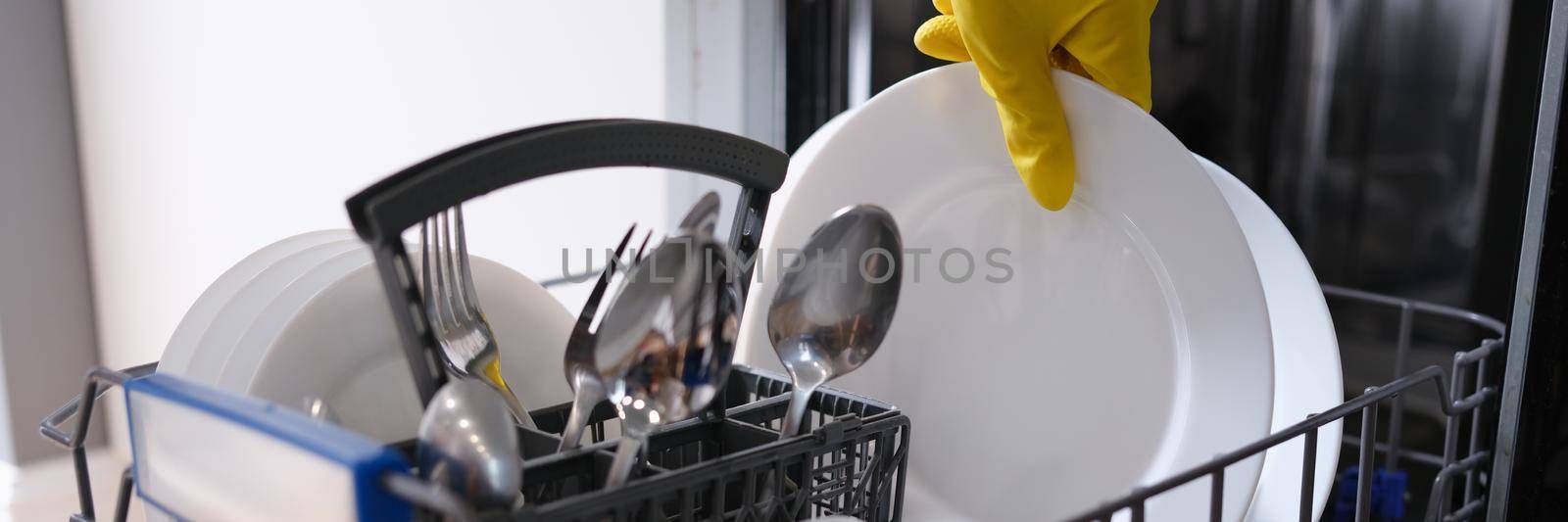 Complete dishwasher with clean washed dishes. Household appliances in the kitchen concept