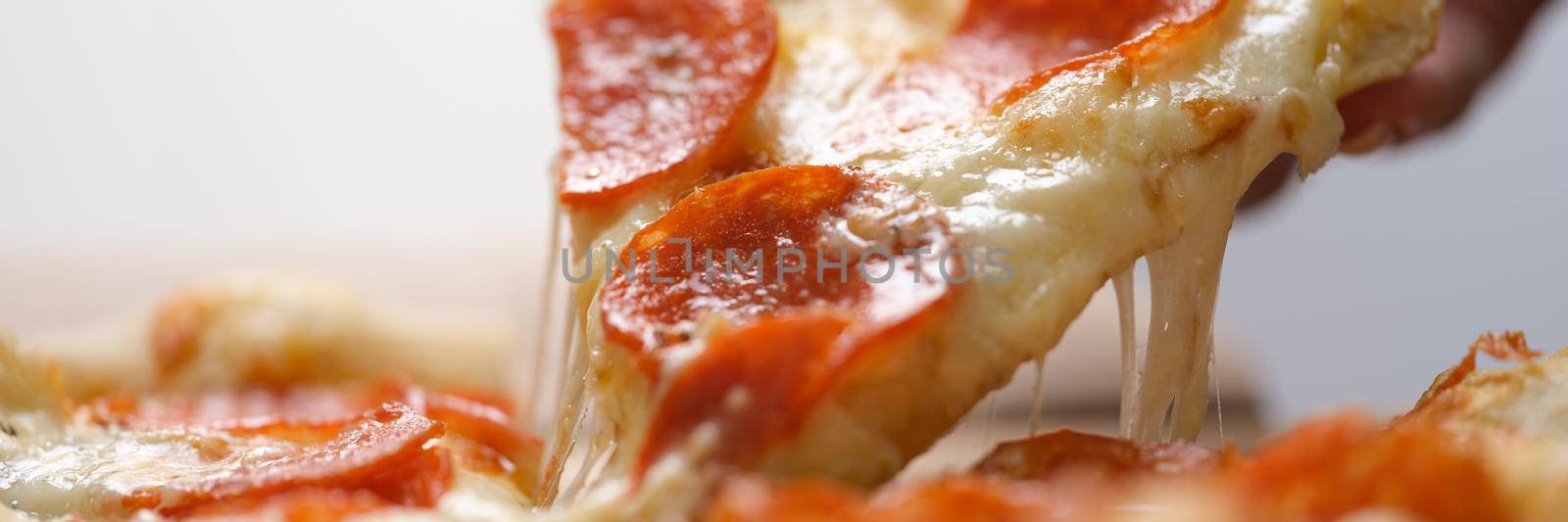 Slice of juicy fresh hot pizza is taken out of box. Pizza delivery concept