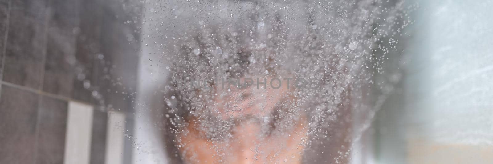 Woman sits in bathtub, water is poured on top of back. Depressed woman taking a bath concept