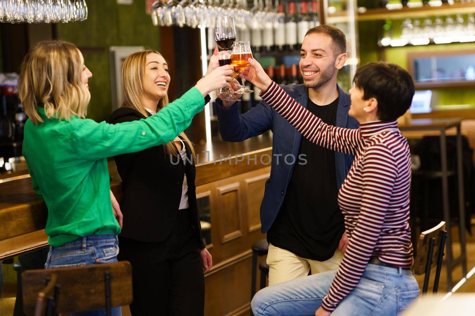 Happy young people proposing toast in a pub by javiindy