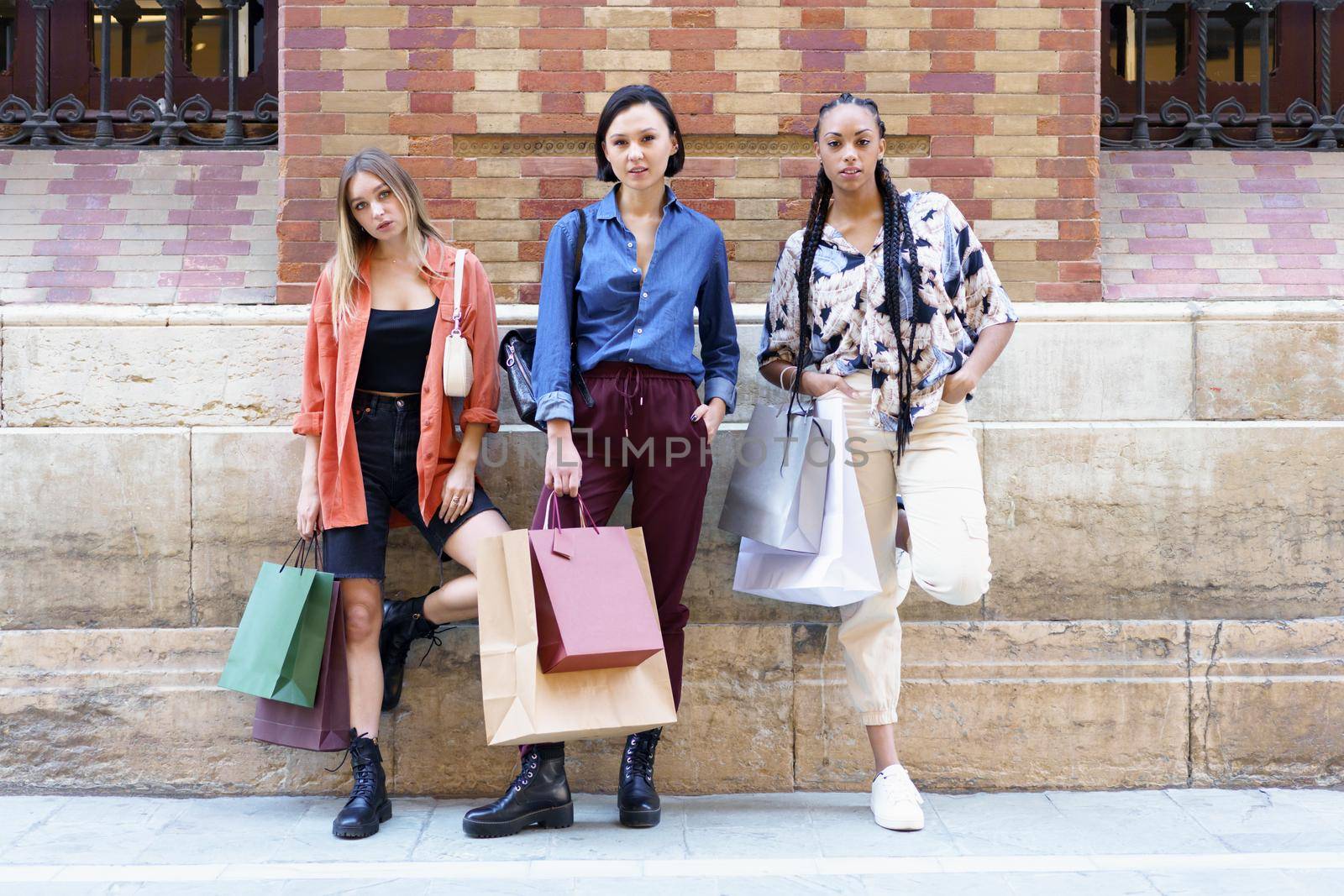 Trendy diverse women with shopping bags by javiindy