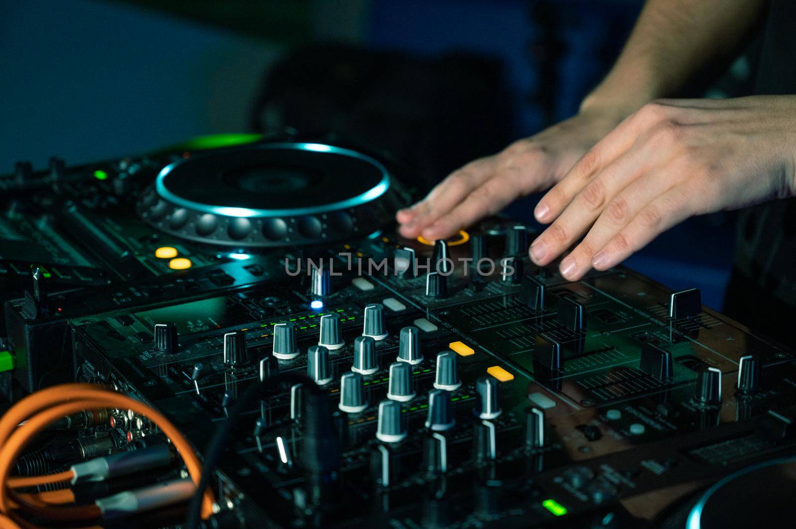 Dj mixing at party festival with light and smoke in background - Summer nightlife view of disco club inside.High quality photography.