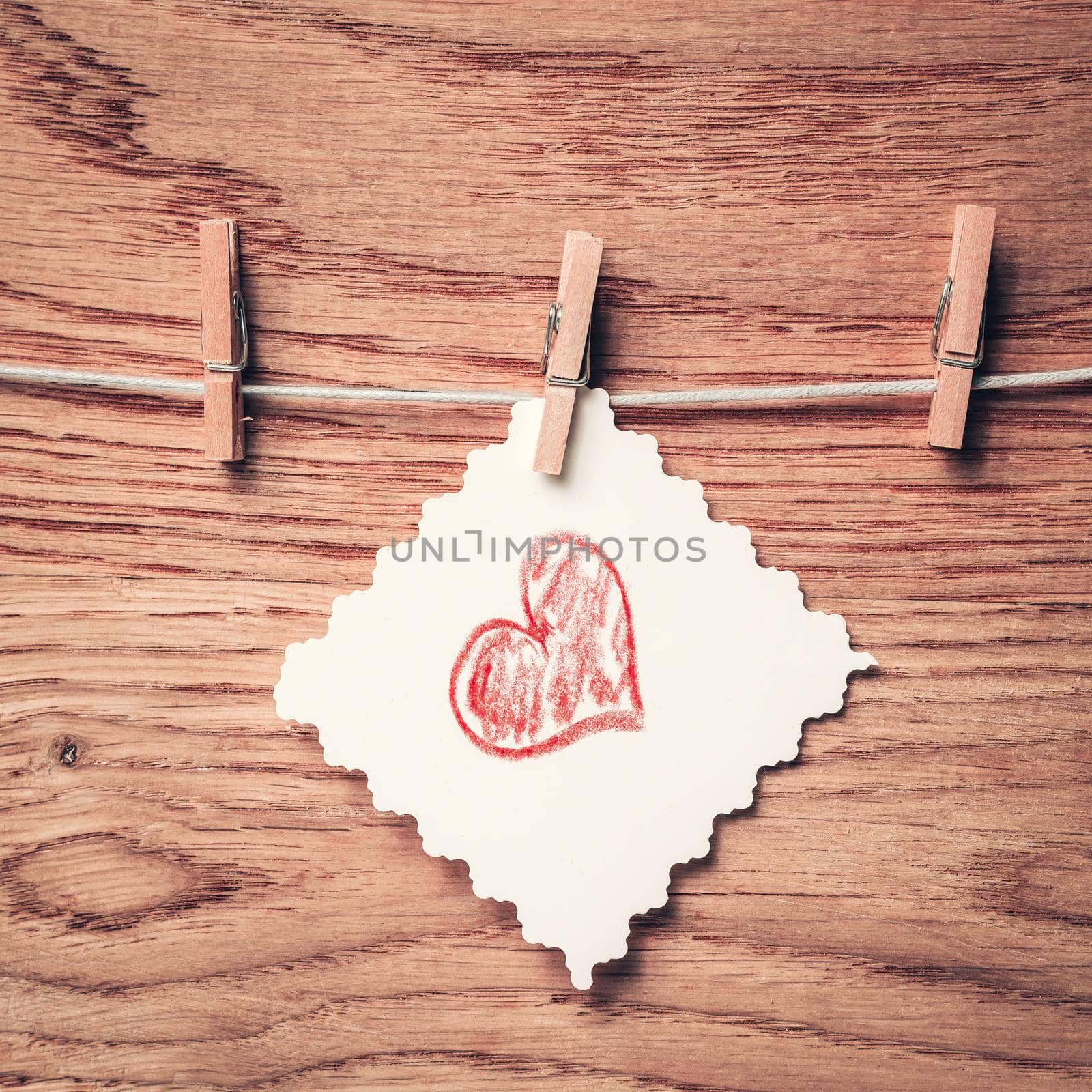 piece of paper with a heart drawn on a clothespin. by SmartPhotoLab
