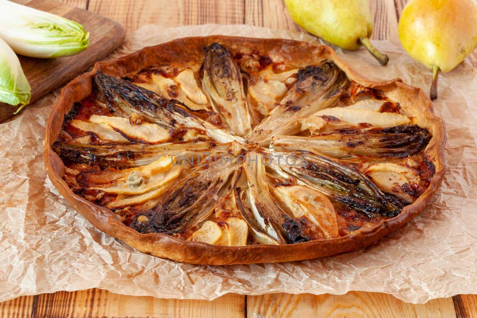 sweety salty tart with the ingredients of chicory and pears, wooden background