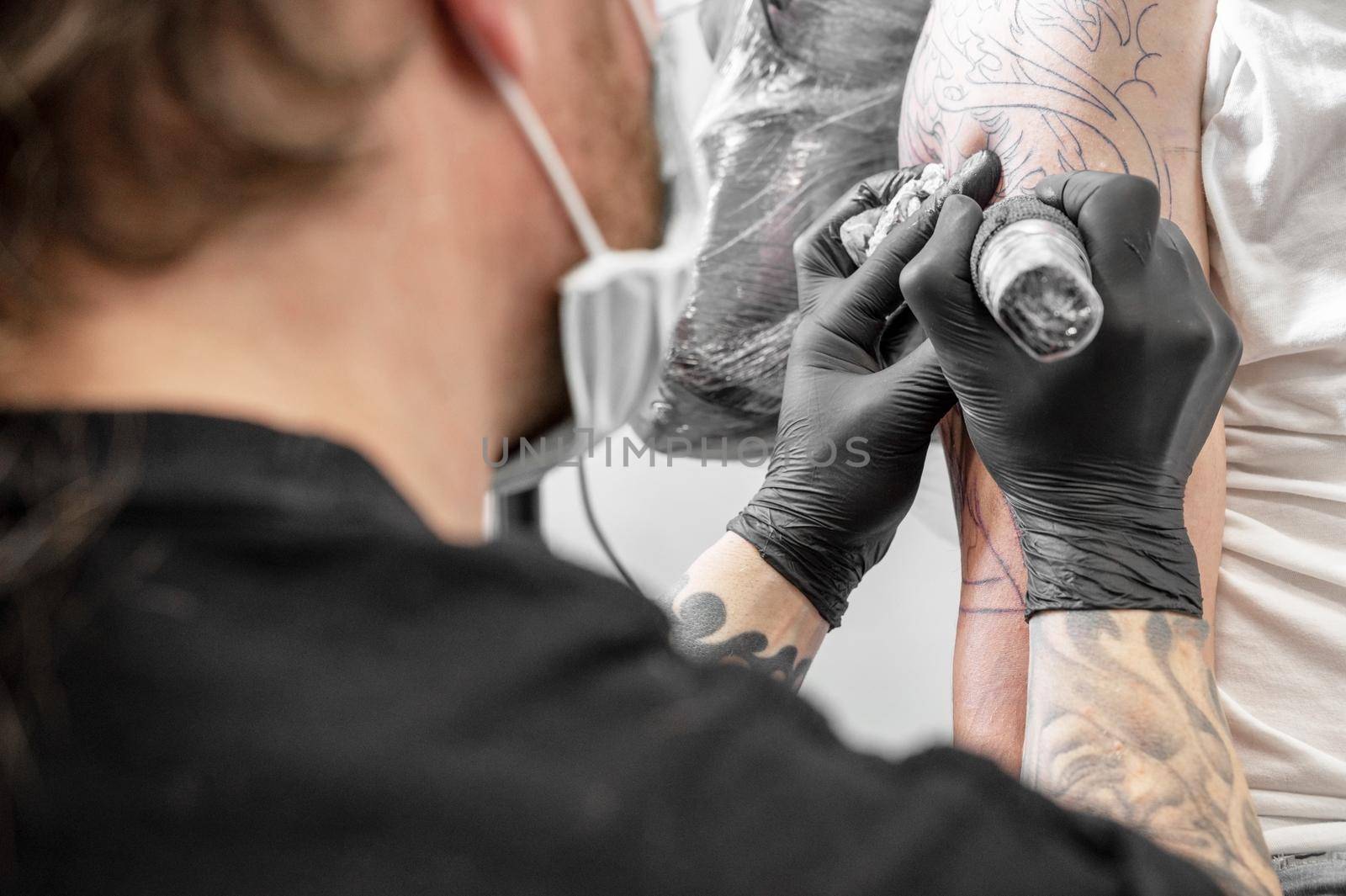 Salon tattoo. Close up of a Tattoo artist working. Tattoo artist make tattoo at the studio. by HERRAEZ