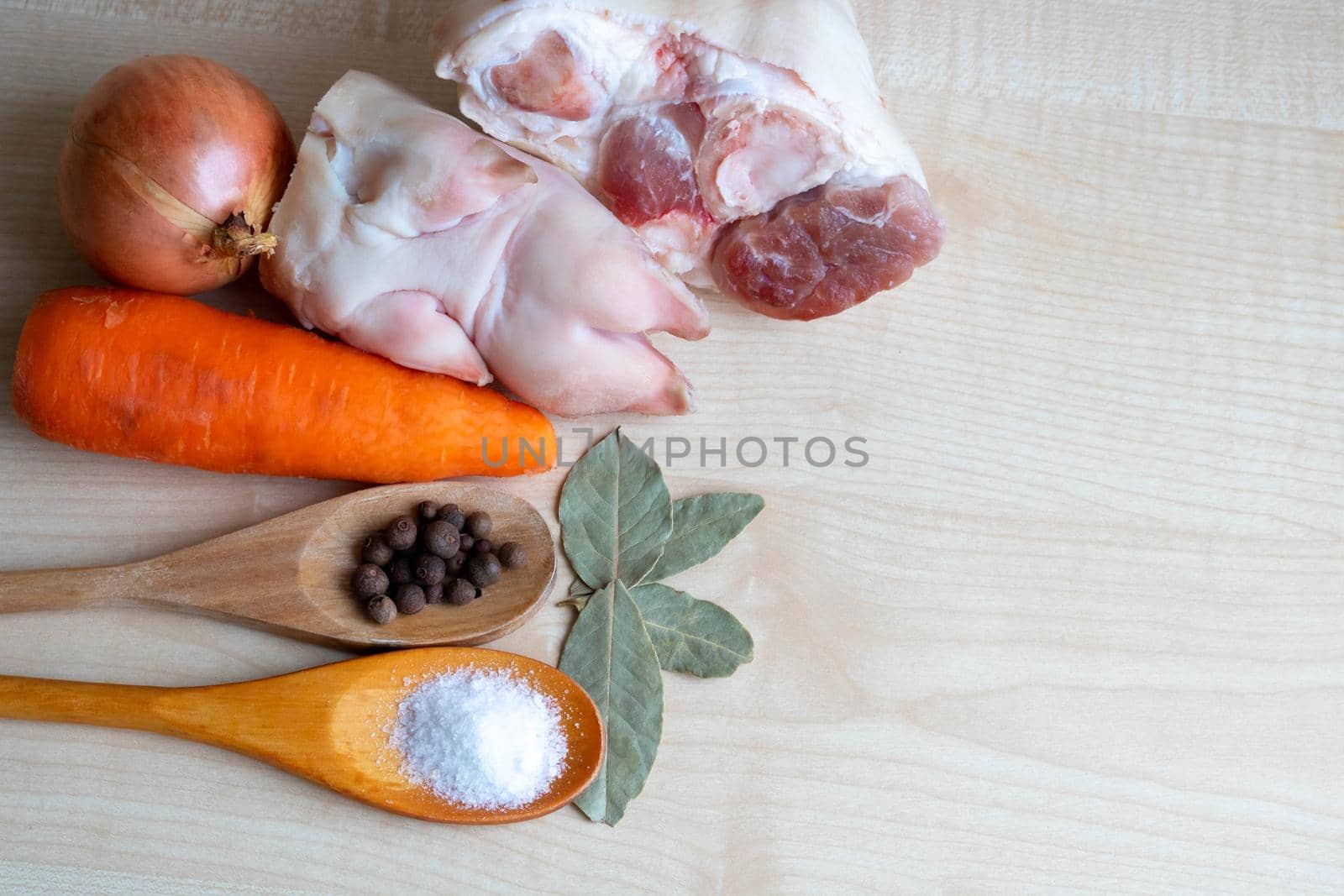 Raw pork meat and leg, carrots and onions, salt and pepper on the kitchen table for making jelly. place for your text by lapushka62