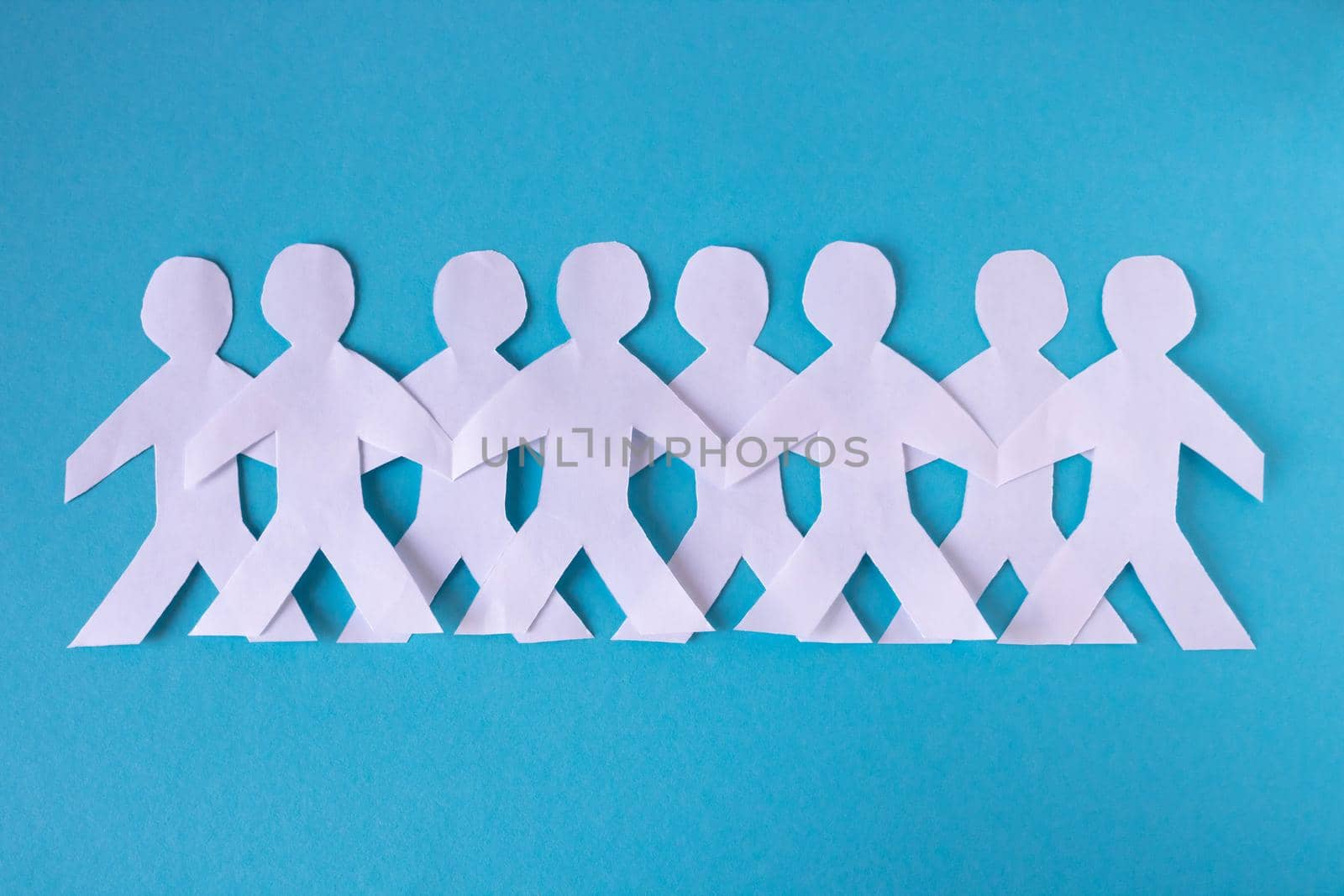 People cut out of paper on a blue background. The concept of the World Peace Day