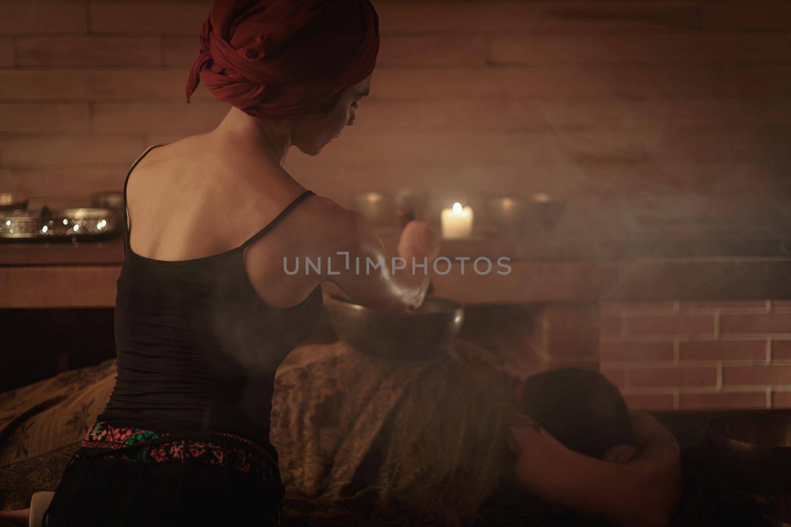 A woman performs a Tibetan ritual with sound bowls. The concept of therapy by Yurich32