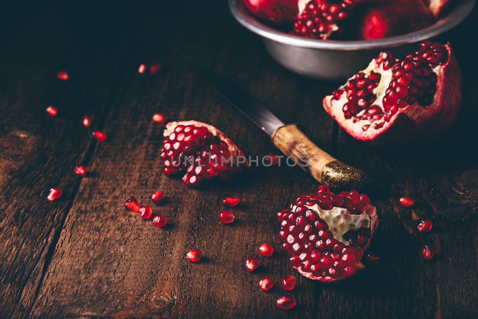Pomegranate pieces on rustic wooden surface by Seva_blsv