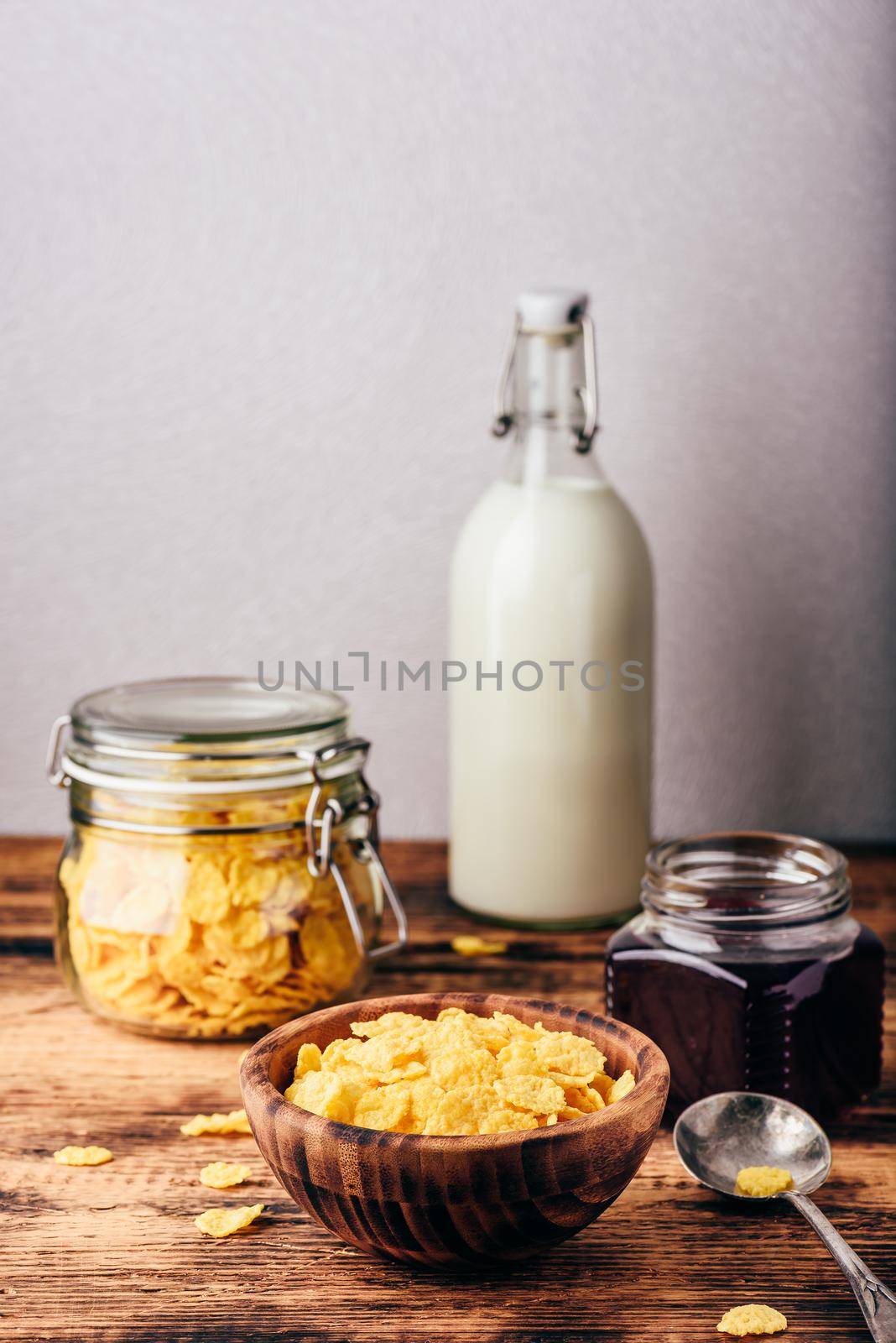 Breakfast with corn flakes, milk and berry jam