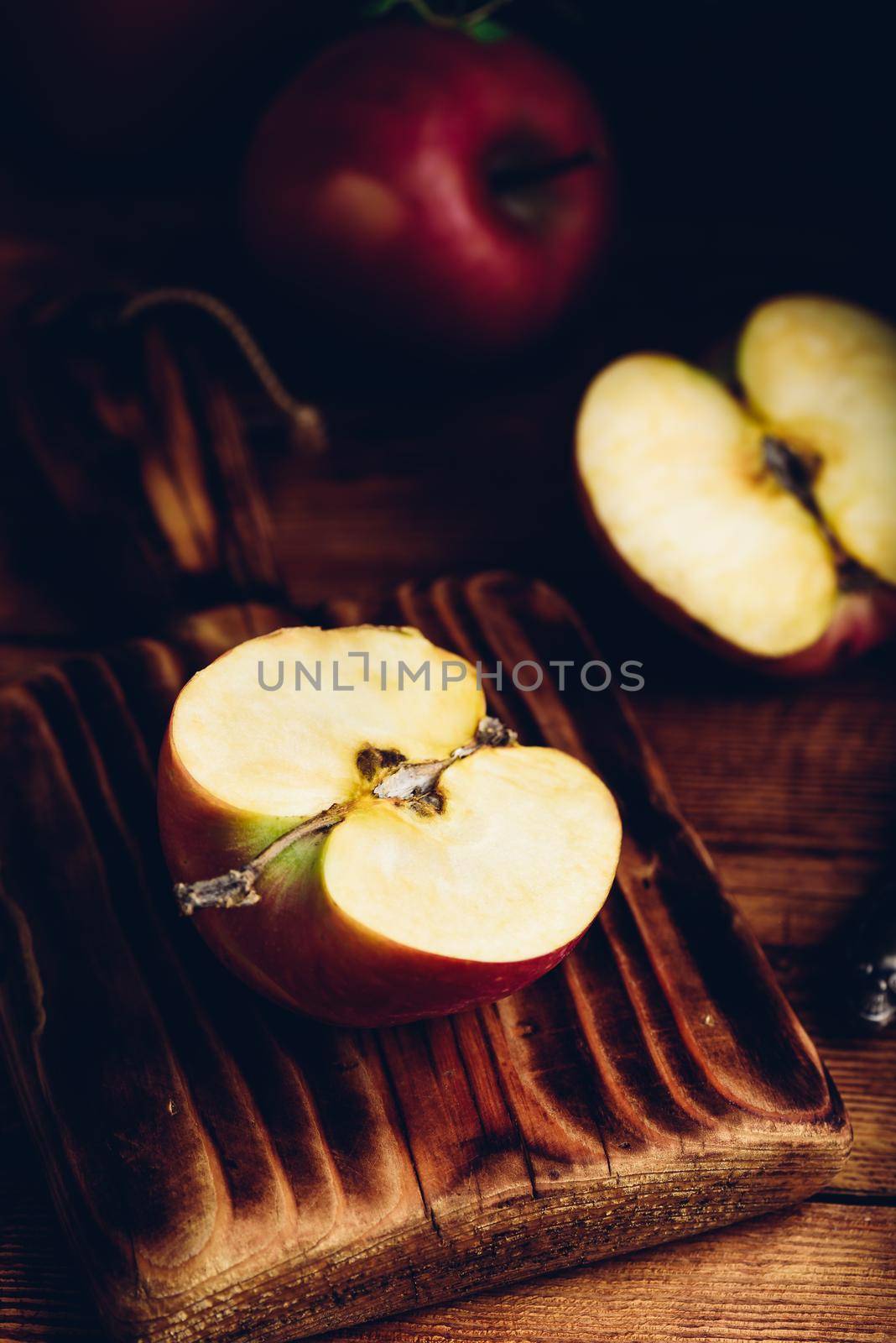 Halved Red Apple on Cutting Board in Rustic Setting