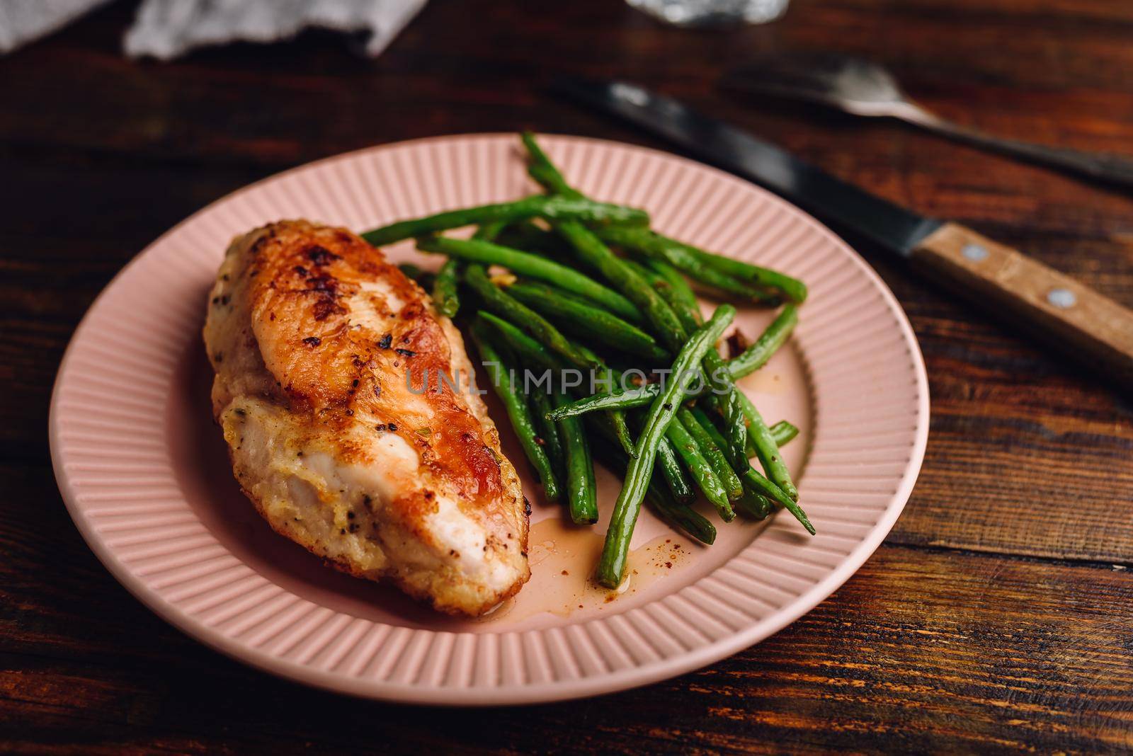 Chicken Breast Baked in Oven and Green Beans Fried with Garlic and Thyme on Plate