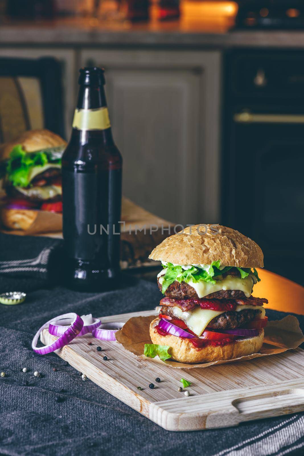 Prepared Cheeseburger on Cutting Board with Bottle of Beer on T by Seva_blsv