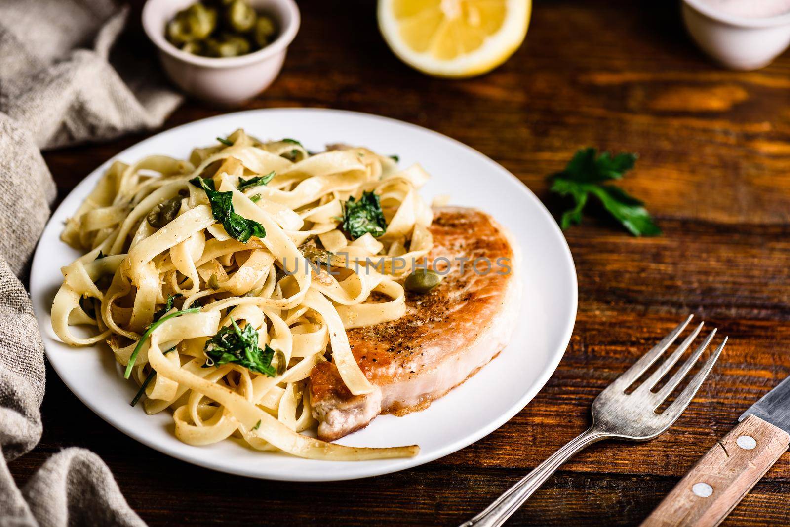 Pork chop steak and pasta with capers and lemon zest