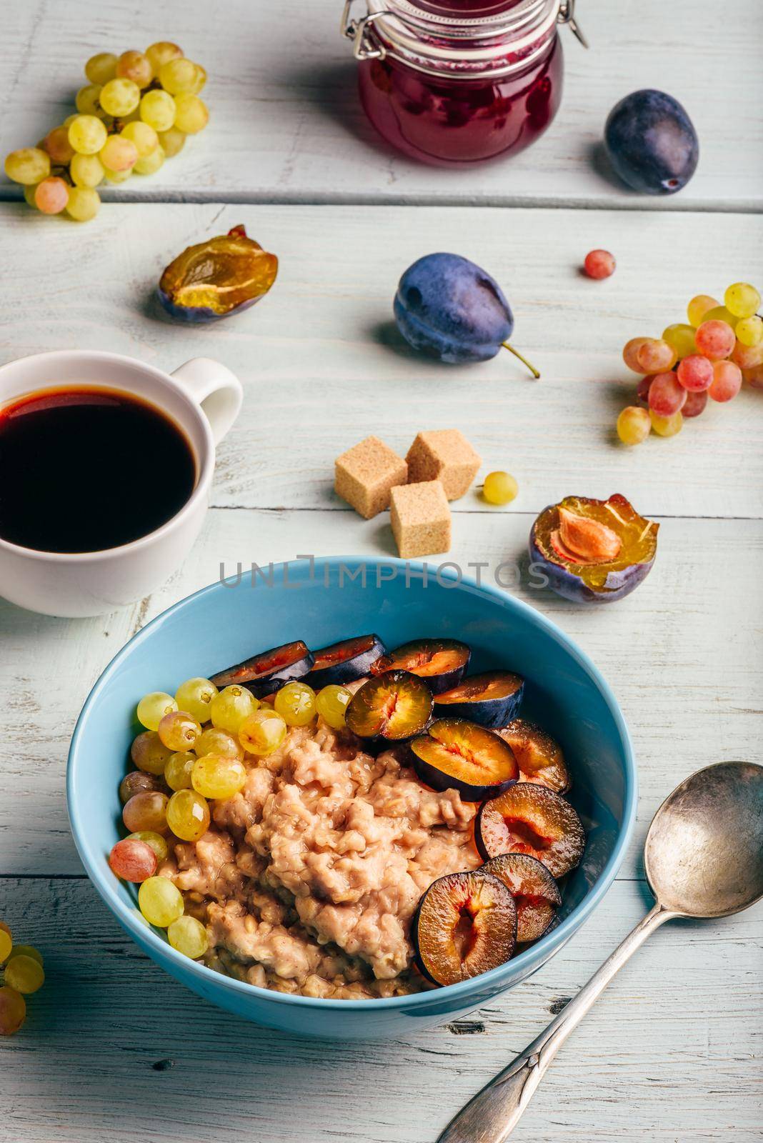 Porridge with fresh plum, green grapes and cup of coffee. by Seva_blsv