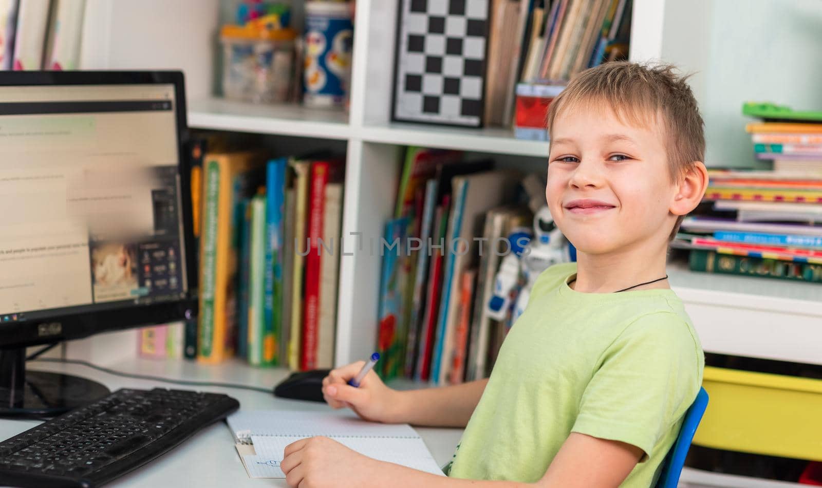 Little young school boy working at home with a laptop and class notes studying in a virtual class. Distance education and learning, e-learning, online learning concept during quarantine