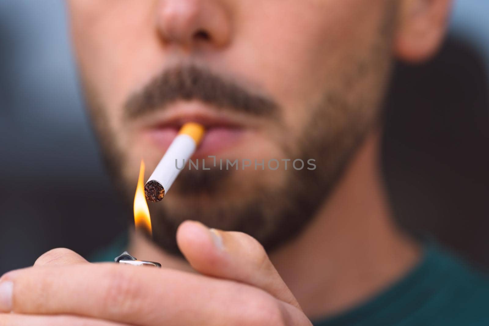 Closeup of young man lighting cigarette with lighter. Smoking cigarette and nicotine addiction by DariaKulkova