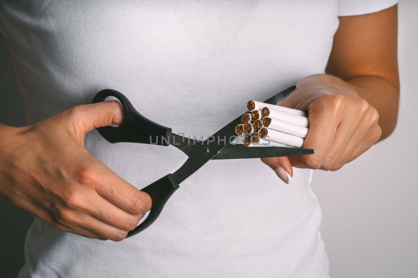 Woman cutting cigarettes with scissors . Stop smoking, quit smoking or no smoking. Woman refusing tobacco and quit bad habit by DariaKulkova