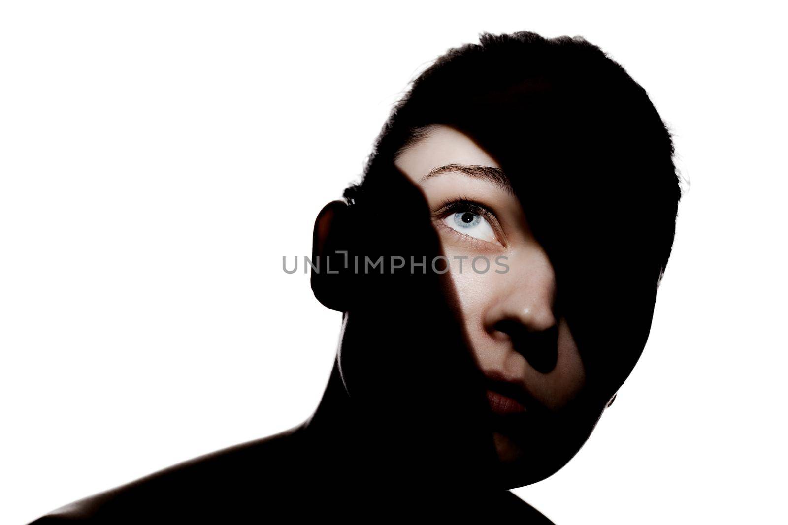 Fashionable studio portrait of a cute girl. Silhouette of a beautiful young woman with hard shadows on her face. against white backgroung by kokimk