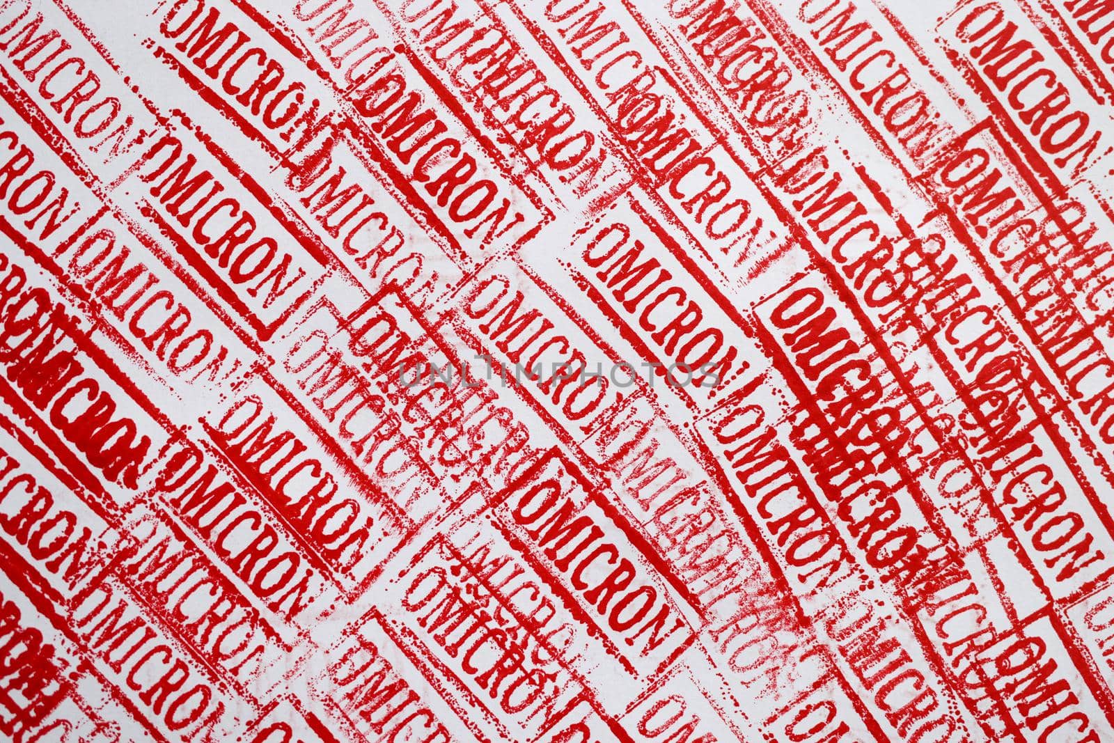 Many red stamps with new variant of coronavirus infection omicron closeup background by kuprevich