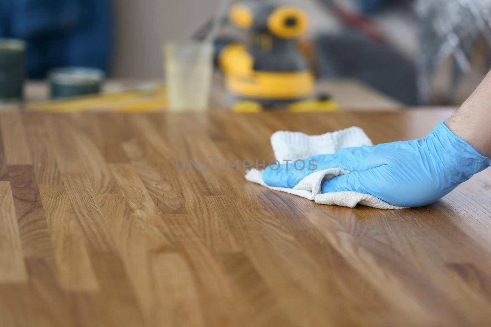 Close-up of carpenter male polish wooden plank with cloth, worker remove dust from wooden surface. Carpentry work, renovation, interior, builder concept