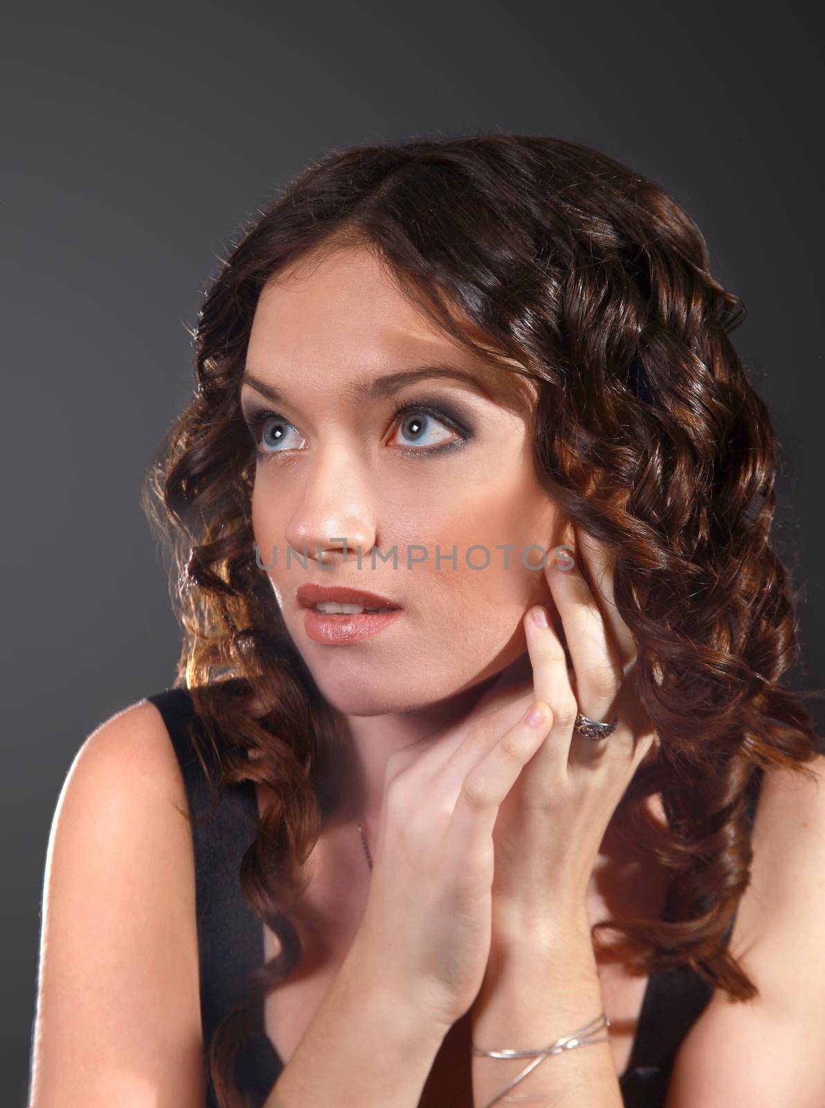 The beautiful young sexual woman on a dark background