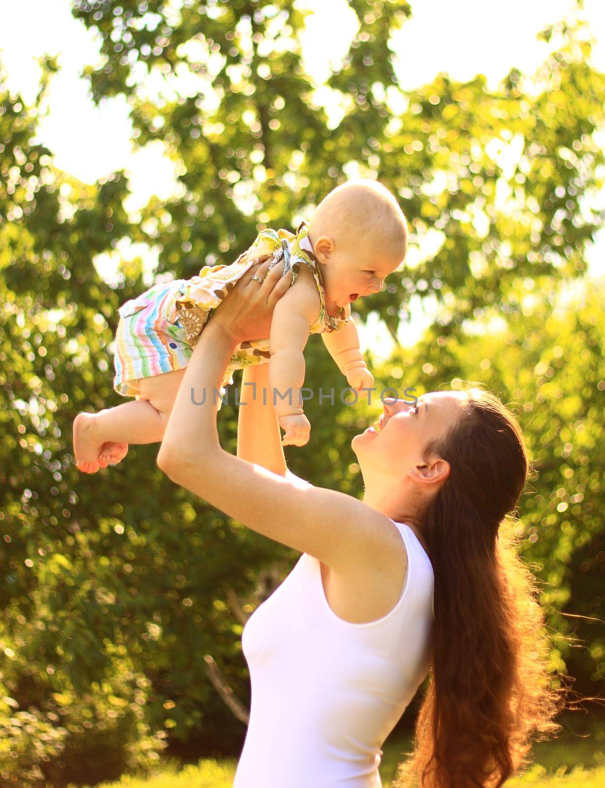 Beautiful Mother And Baby outdoors. Nature. Beauty Mum and her Child playing in Park together