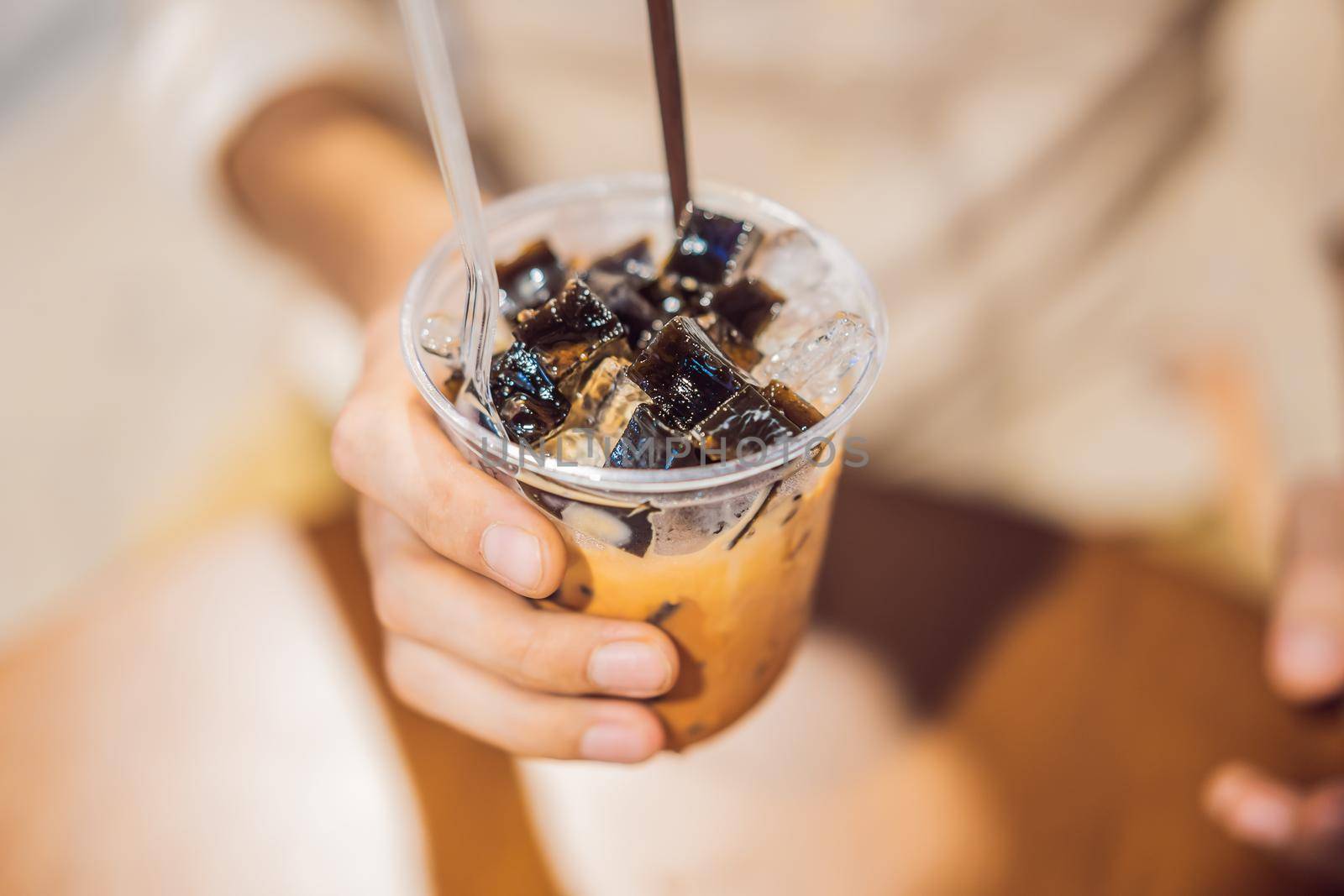 Man drinking cold bubble tea in cafe by galitskaya