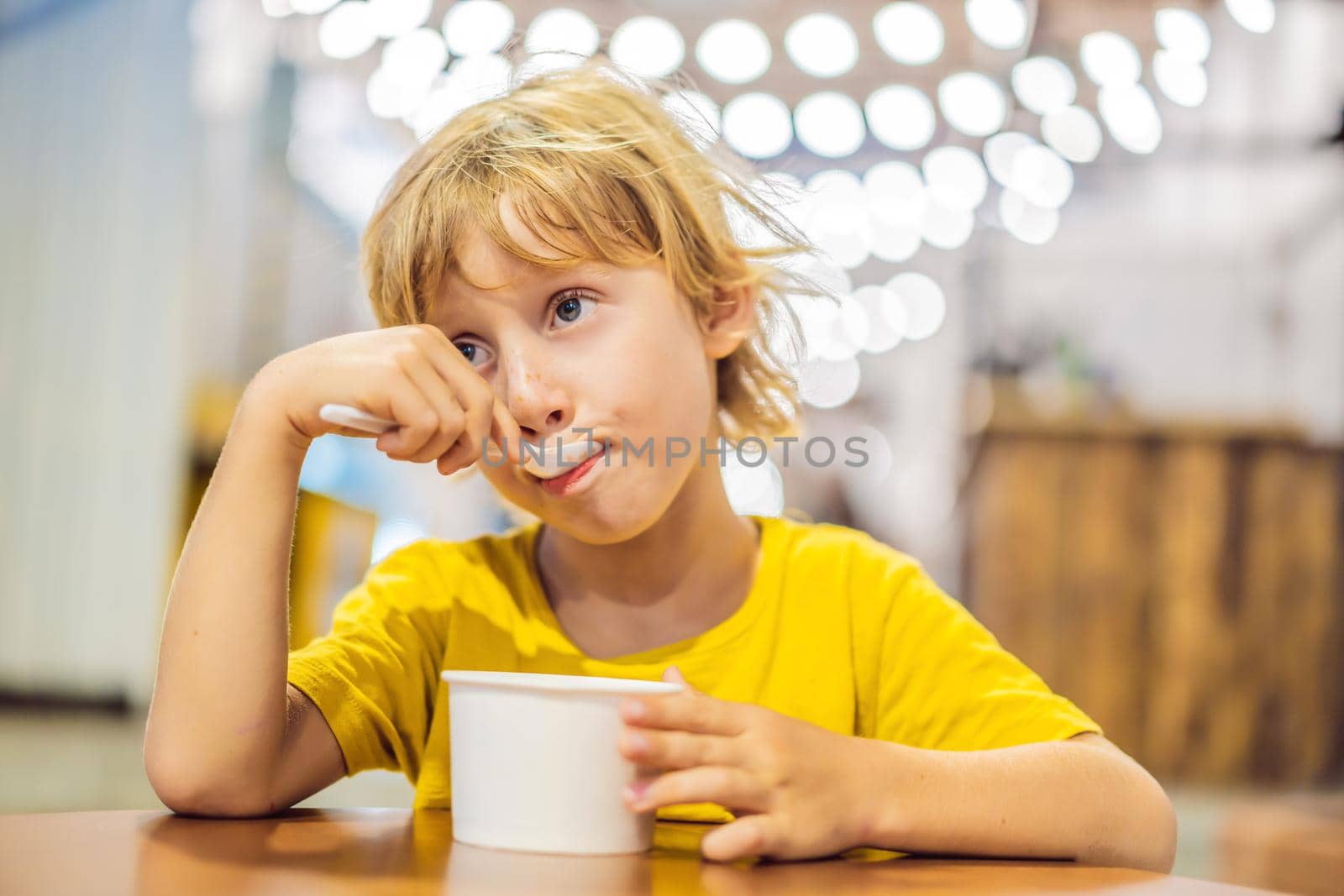 Boy eating ice cream in a cafe.