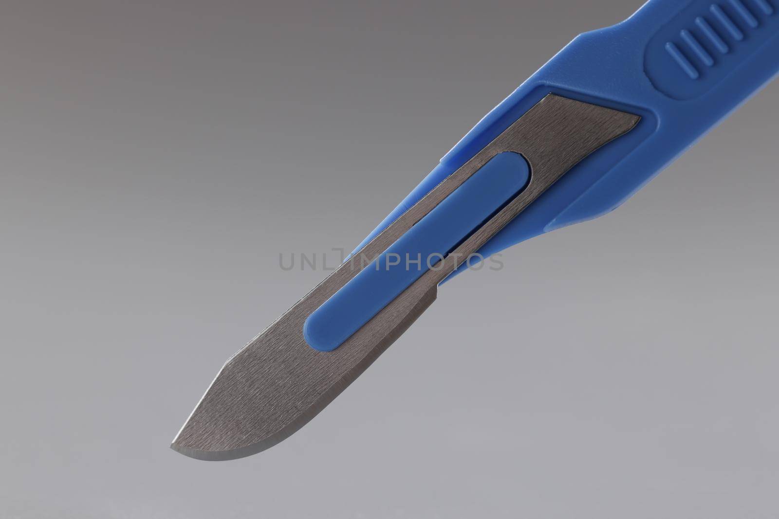 Close-up of retractable pocket sized box cutter, sharp instrument in blue colour knife. Household box cutter tool for utility purpose. Stationery concept