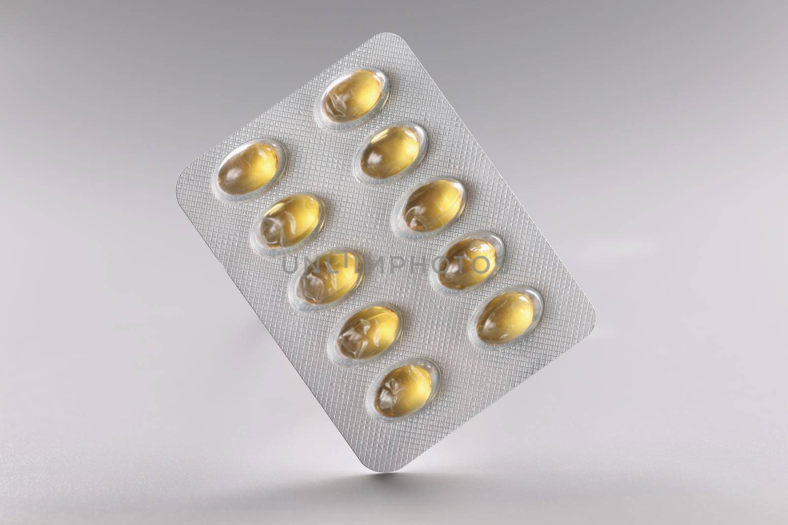 Close-up of blister with yellow jelly tablets, daily dose of medication for person. Pills in plastic package. Prescription, treatment, medicine concept
