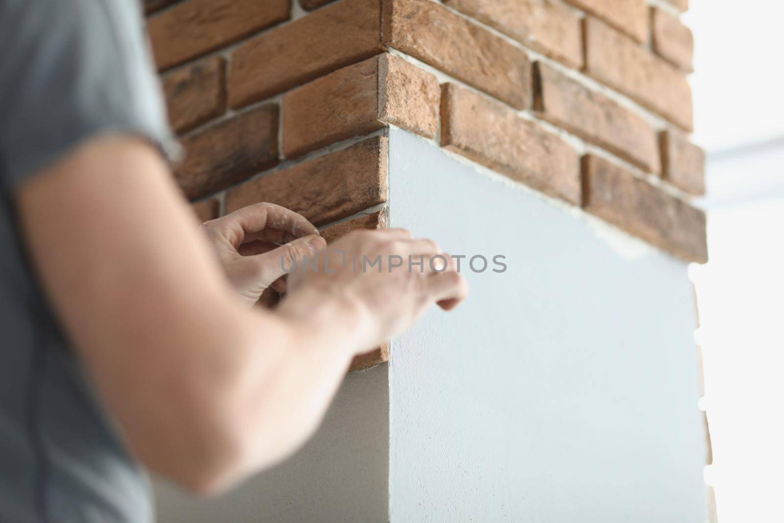 Close-up of professional builder put bricks on wall in apartment, handyman work on new project. Complete full designing idea. Interior, renovation concept