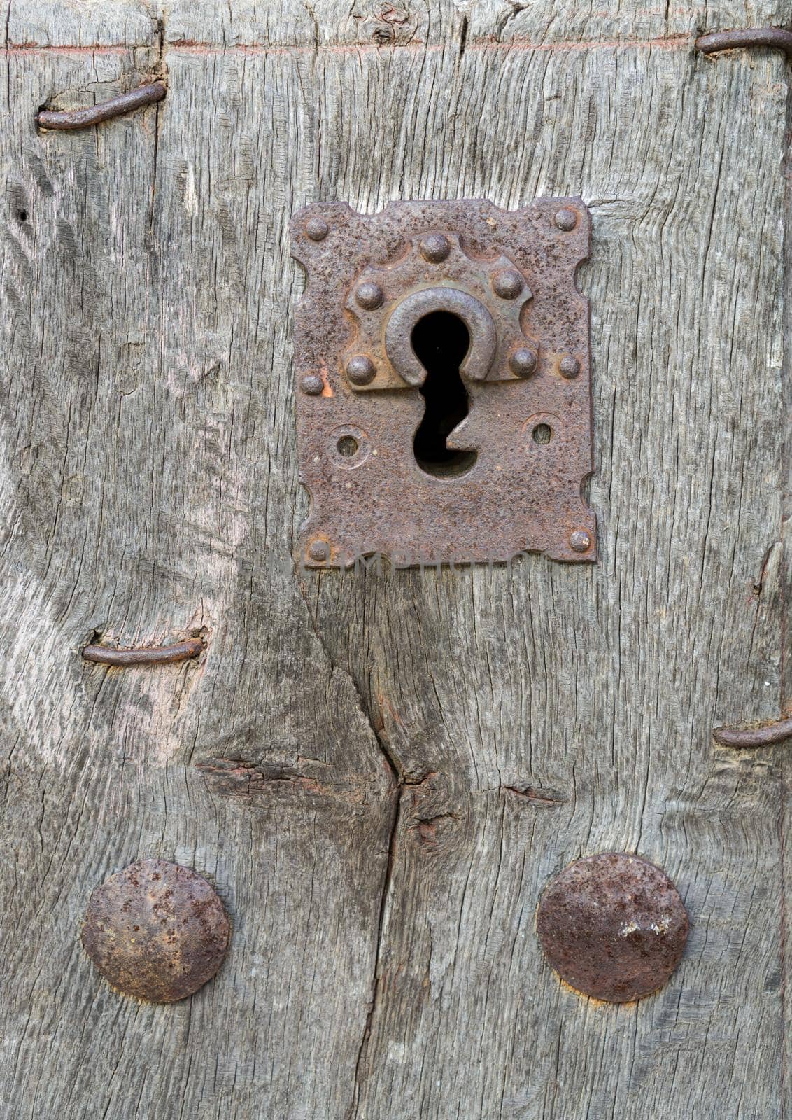 Closeup of vintage run-down wooden door and rusty iron lock