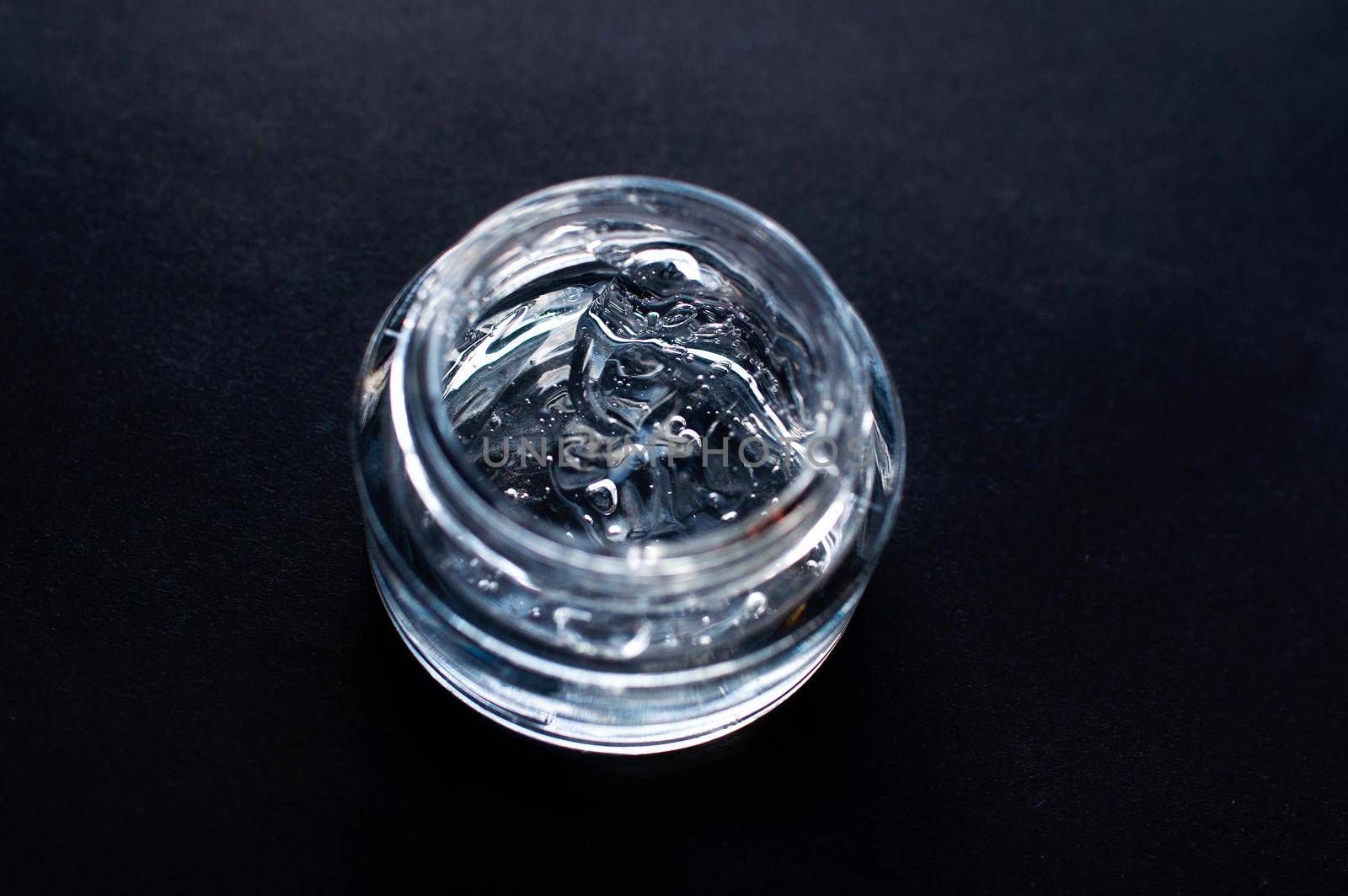 Transparent cosmetic gel for skin care with bubbles close-up on a black background