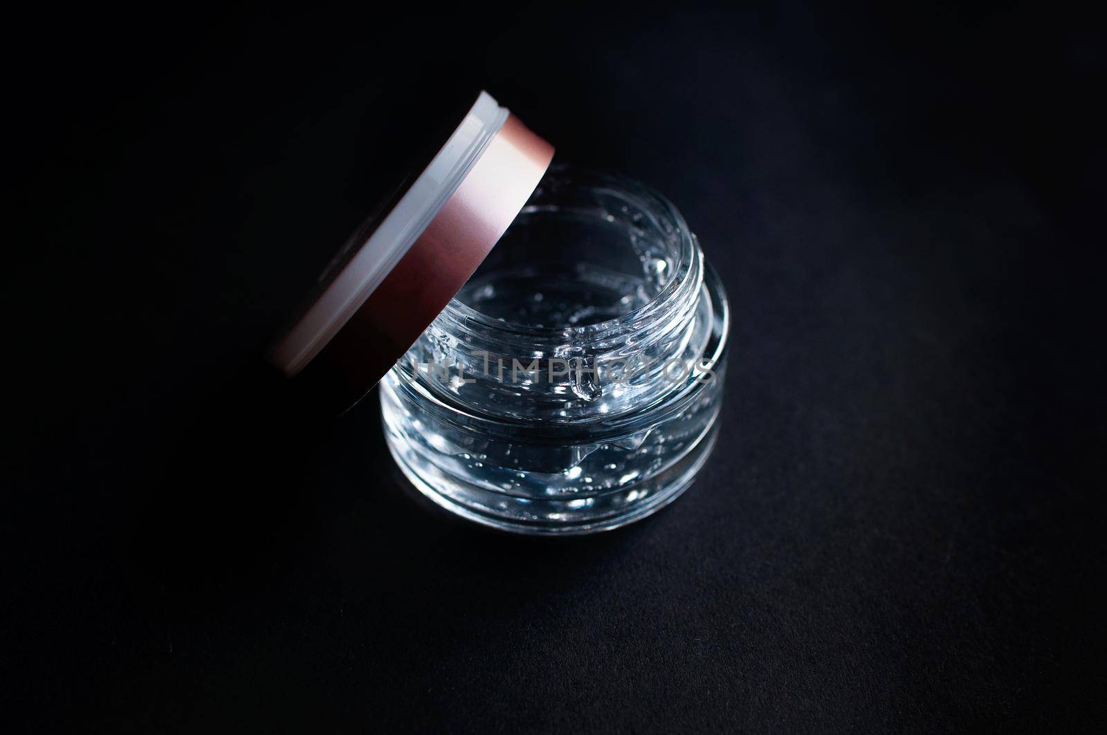 transparent jar with hyaluronic acid moisturizing gel on a black background