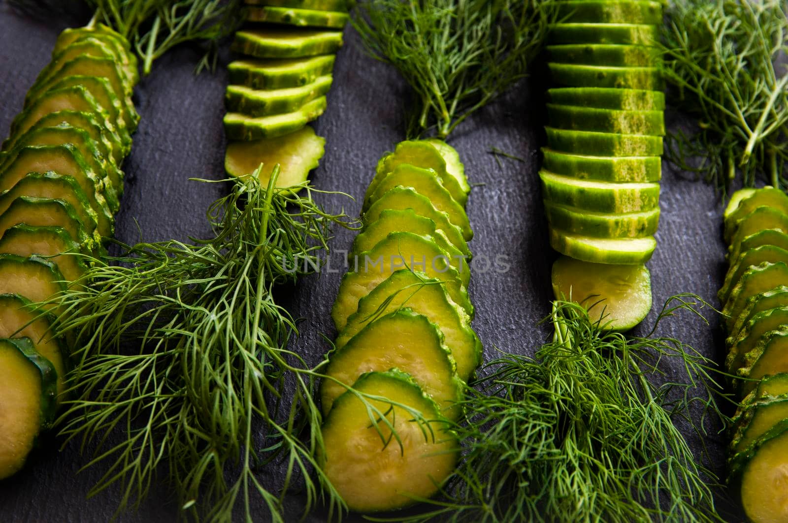 Natural fresh green cucumbers from a home garden on a black background by ozornina