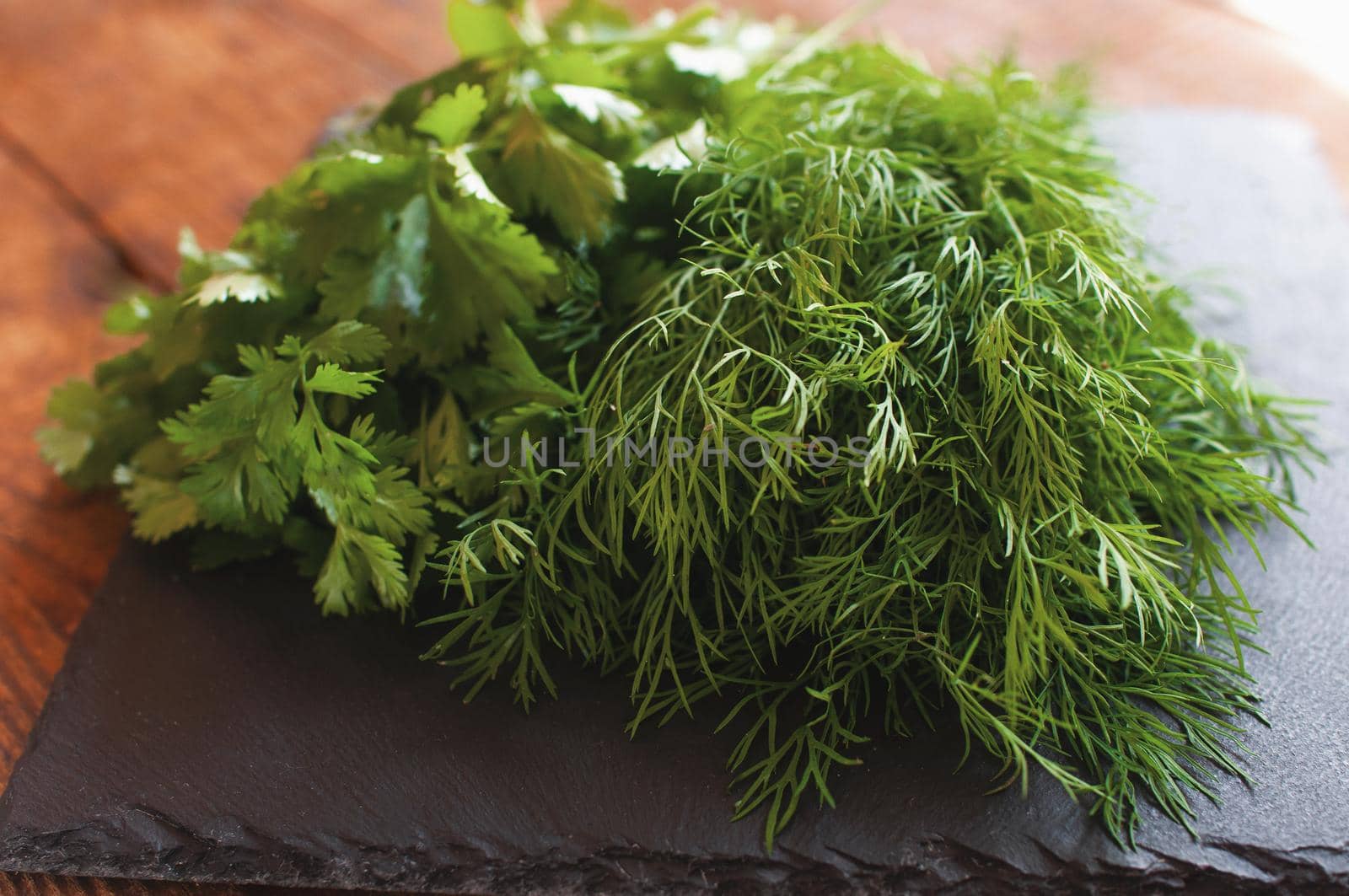 fresh arugula dill and parsley lies on a black board