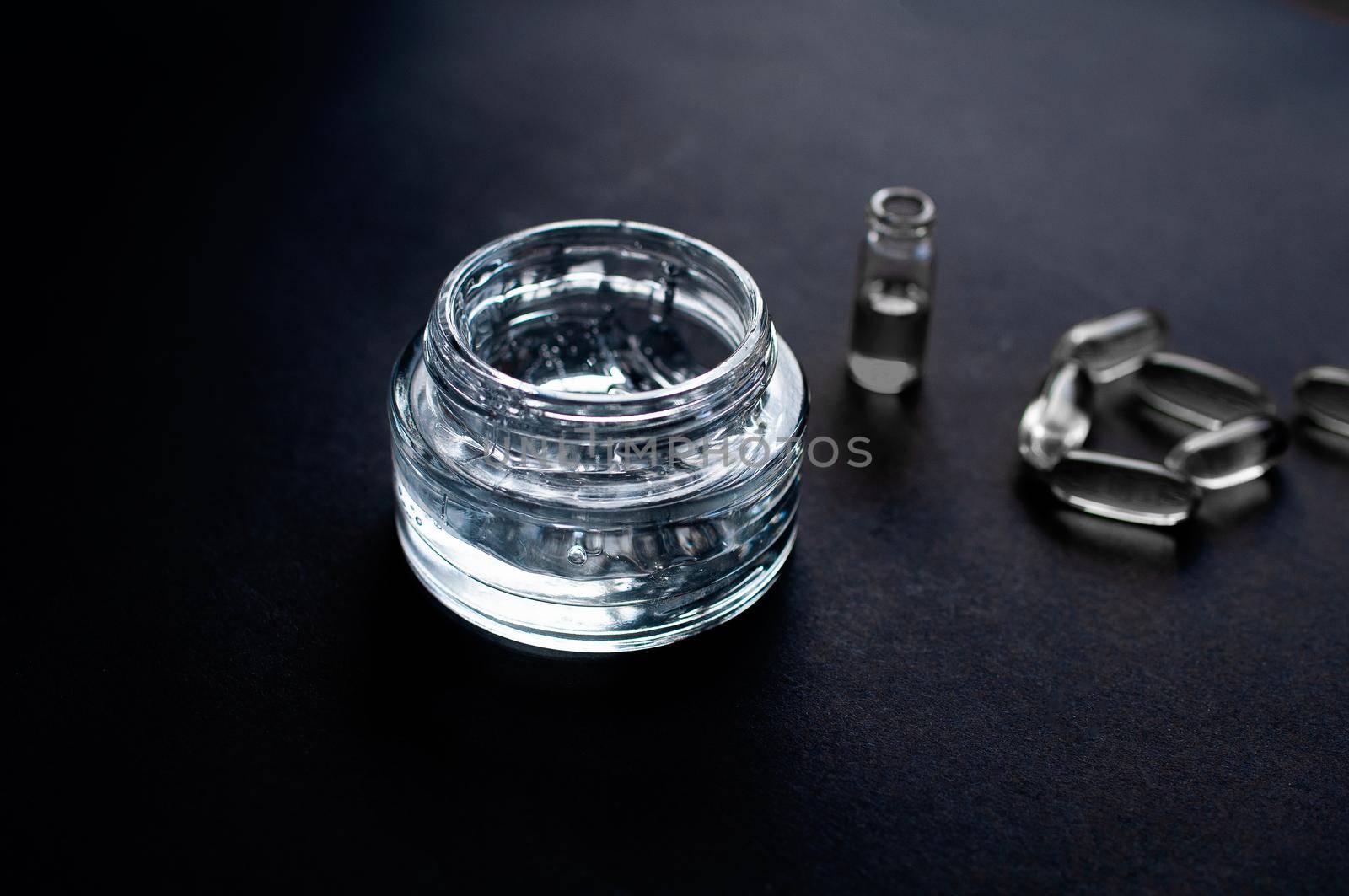 transparent jar with moisturizing cream with hyaluronic acid on a black background