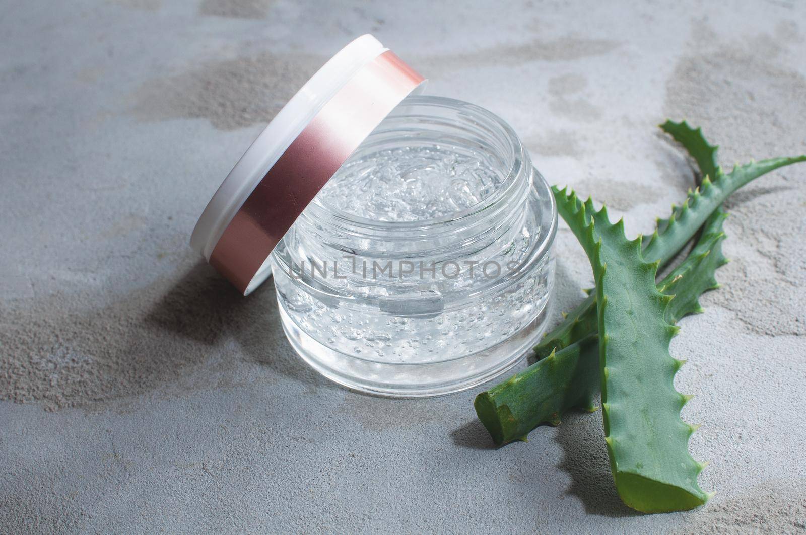 Gel texture with bubbles hyaluronic acid and aloe vera branches in a glass jar  by ozornina