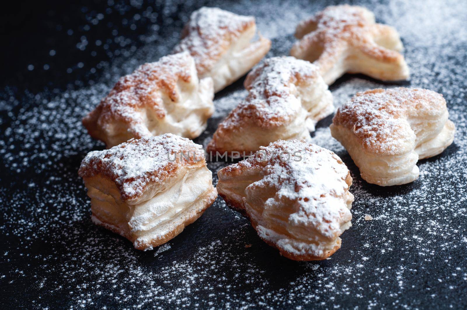 Christmas puff pastry cookies on a black slate background by ozornina