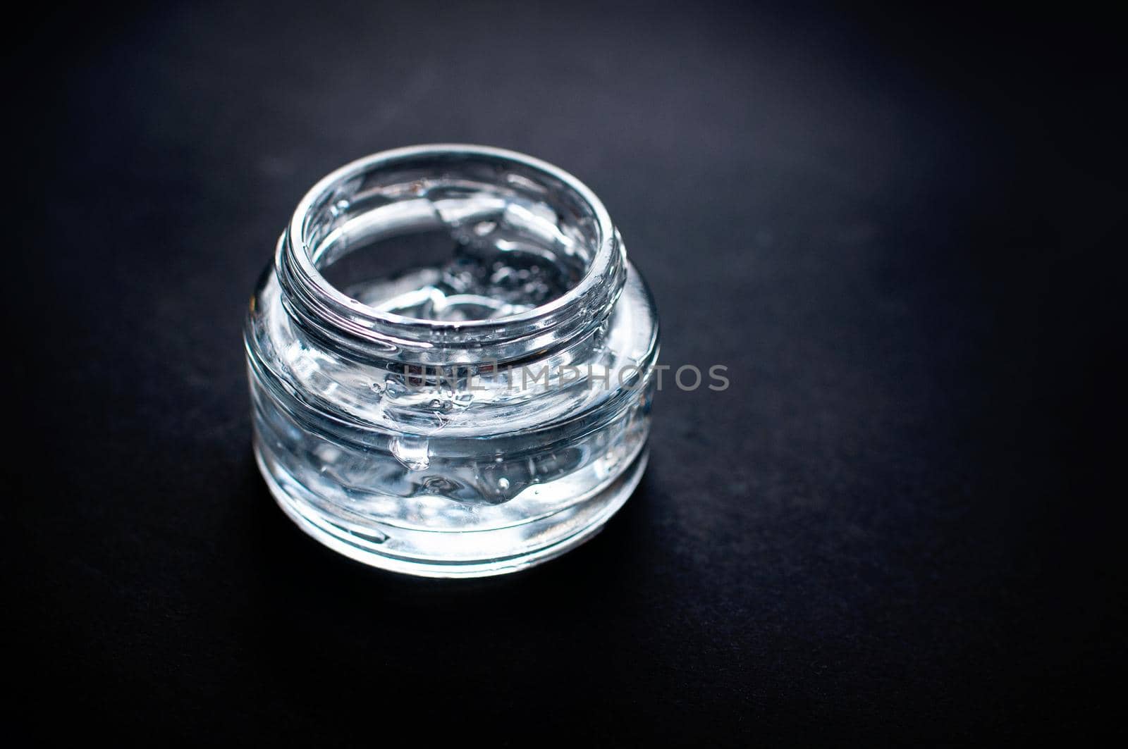 transparent jar with moisturizing gel with hyaluronic acid on a black background