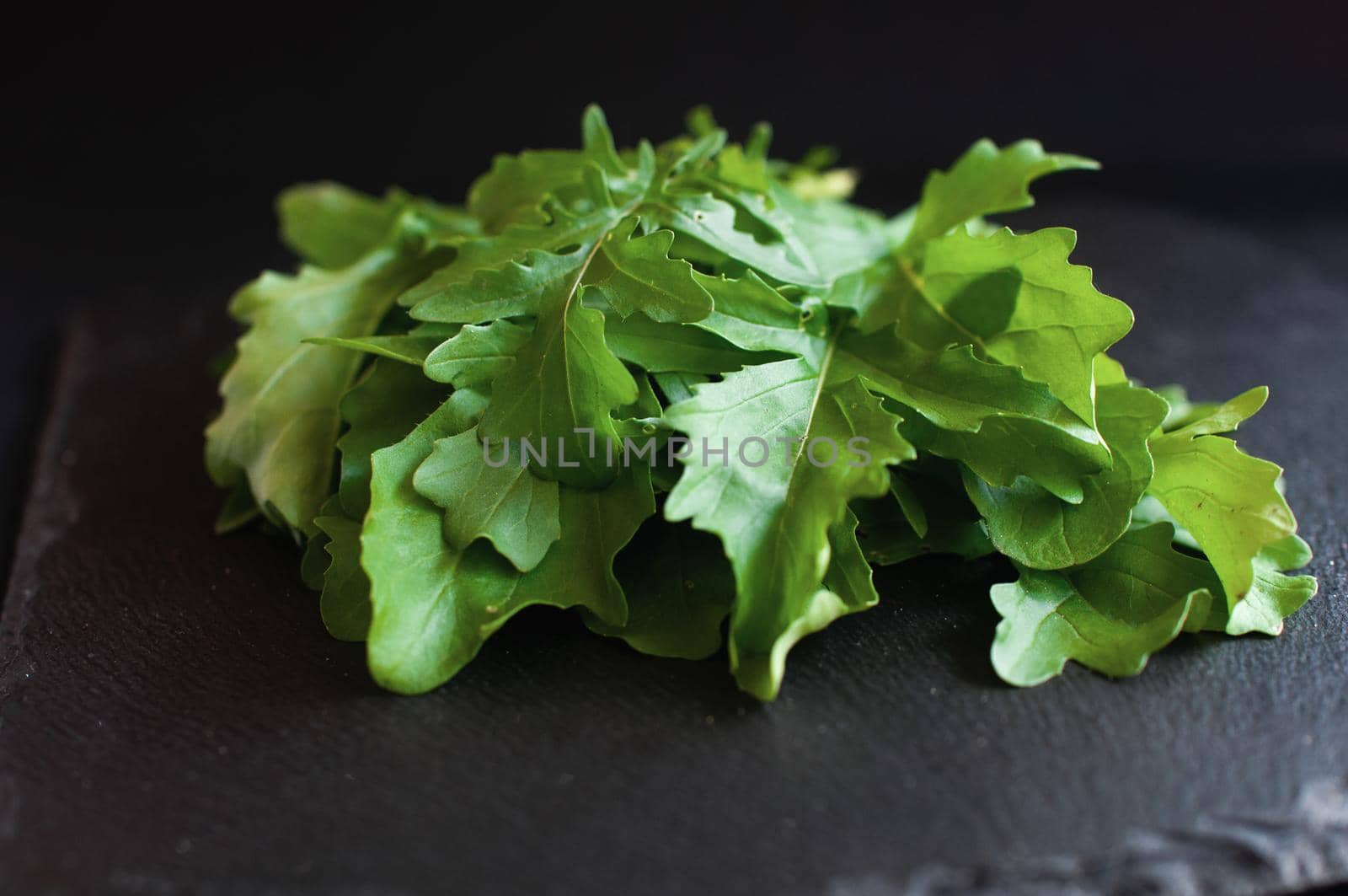 fresh arugula on a black board by ozornina